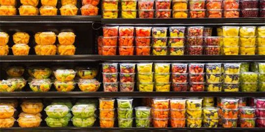 Assortment of cut fruit in plastic containers on display for sale at the supermarket Assortment of cut fruit in plastic containers on display for sale at the supermarket