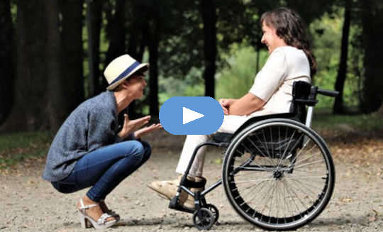 The Ups and Downs of Caregiving caring person squatting down in front of another in a wheelchair