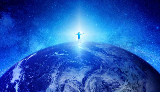 one sole human figure standing on top of planet earth