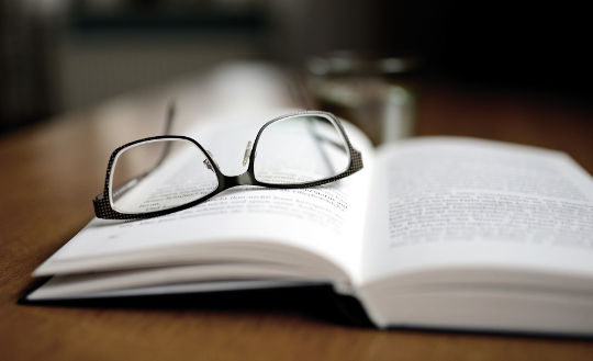 Apply the Book You Read an open book with a pair of glasses laying on it