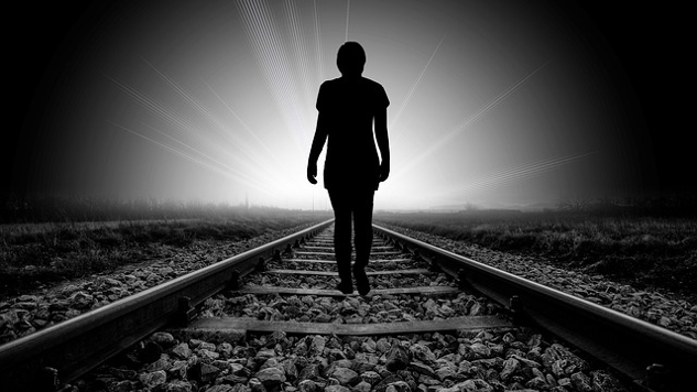 The Pain and Loss of Death: The Ultimate Healer and Teacher silhouette of a person walking on a railroad track towards the light