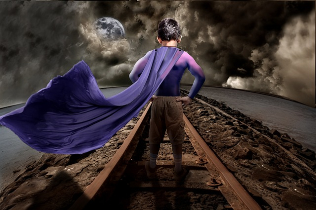 When It’s Not Your Time to Die young boy standing on a railroad track and wearing a superhero cape