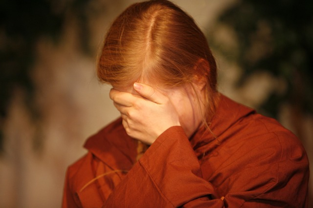 a person with their face hidden in their hands in despair