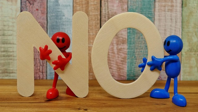 Finding Refuge in Denial: Why We Resist Climate Reality two figures, one red one blue holding up the letters NO. Image by Alexa from Pixabay.