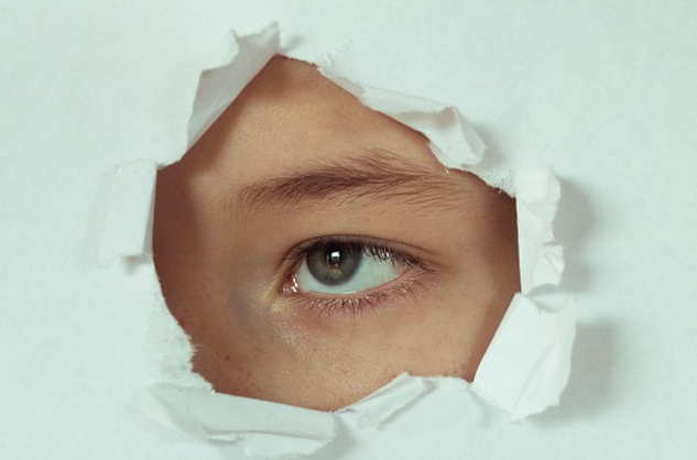 From Breakdown to Breakthrough: Turn Struggles into Strength. A person looking through a punched-out hole in a sheet of paper. Image by Victoria from Pixabay.