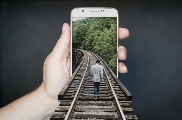 Image of a person walking on the train tracks and somehow entering into a phone in someone's hand.&nbsp;Image by David from Pixabay.&nbsp;
