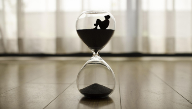 Person sitting in the top of an hourglass with the sanding falling through to the bottom.&nbsp;Image by xaviandrew from Pixabay.&nbsp;