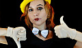 a young woman wearing a bow tie and a clown face with white gloves giving a thumbs up and thumbs down