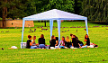 Photo of a group gathered under an outdoor canopy. Image by Thomas G. from Pixabay.&nbsp;