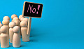 wooden figures of people holding up a sign that reads: "No!"